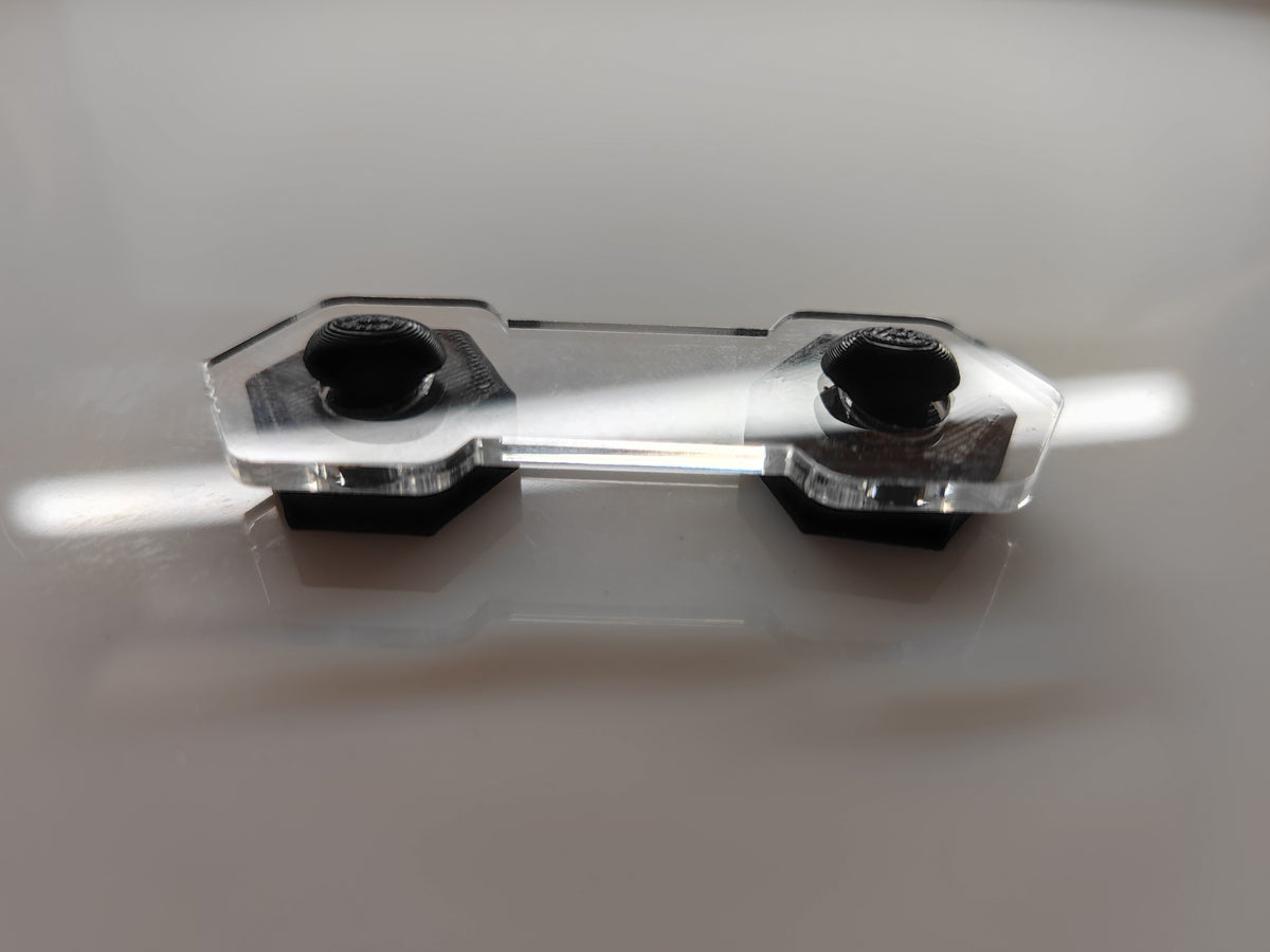 Transparenter Aquakallax Bucen-Box Magnetgegenhalter mit zwei schwarzen Befestigungselementen in der Detailansicht auf weißem Hintergrund