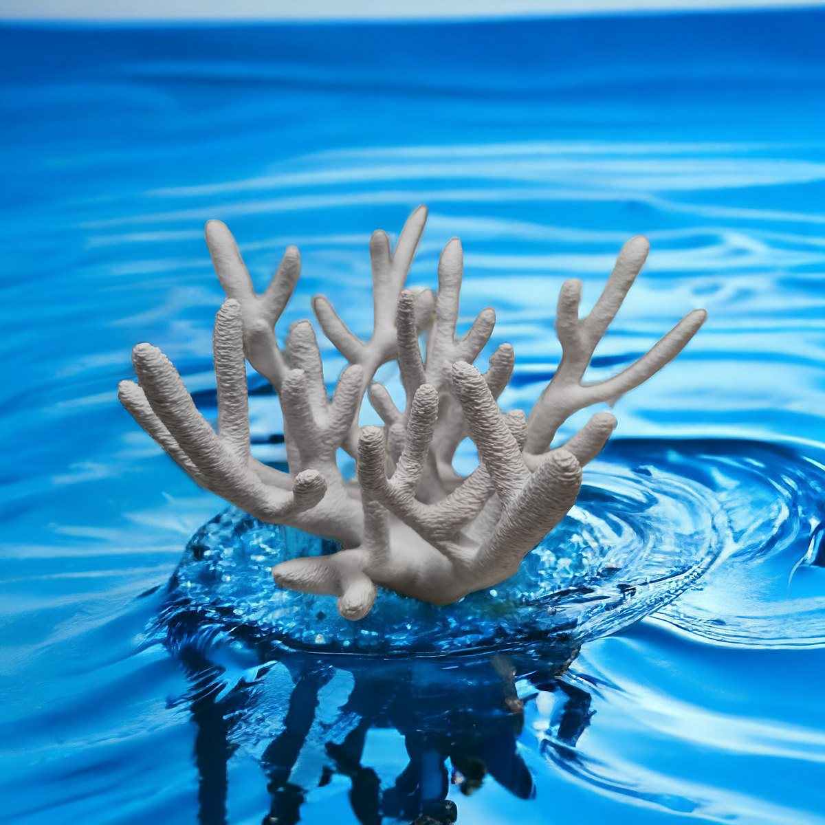 Weißer Aquakallax Magnetic Coral Fragträger mit vielen aufrechten Ästen und rundem Sockel vor blauem Wasserhintergrund