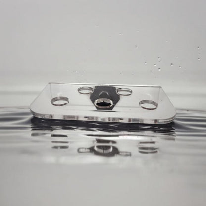 Transparenter Aquakallax ReefDeck für fünf Korallenplugs in der Frontansicht mit runden Öffnungen und schwarzem Magnethalter auf Wasserhintergrund