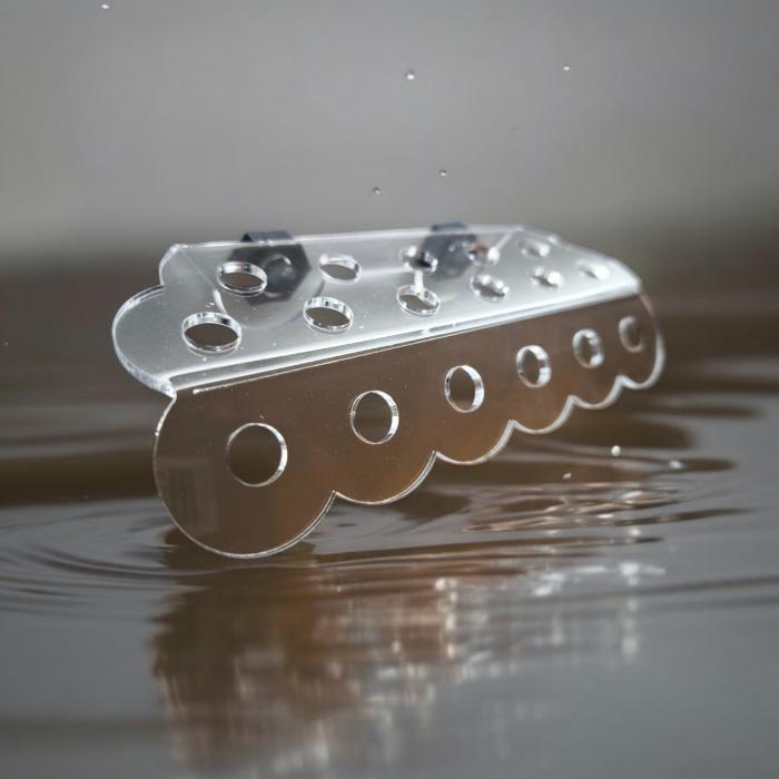 Transparenter Aquakallax ReefDeck für 17 Korallenplugs in Bubble-Form mit runden Öffnungen und zwei Magnethaltern vor Wasserhintergrund