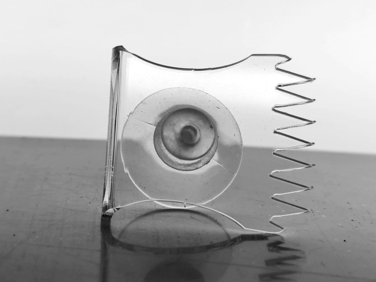 Transparenter Aquakallax Easy-Fix-Mattenhalter mit rundem Saugnapf und Haltezähnen in gerader Detailansicht